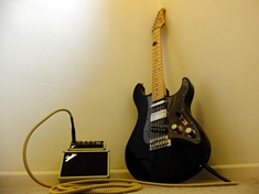 This is a Yamaha Pacifica 112, after a pickguard- and electronics-ectomy. Pictured here with one of my favourite amps!